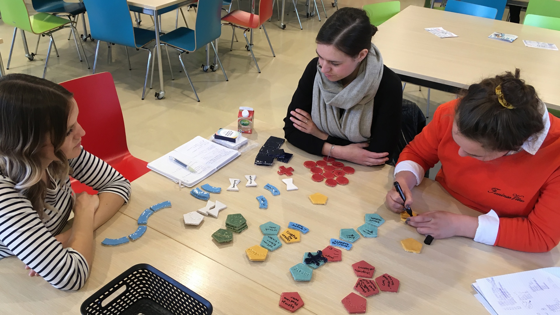 Studenten schrijven op tegeltjes