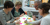 Personen aan een tafel die bezig zijn met een brainstormsessie - Cursus idee ontwikkeling voor food concepten