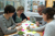 Personen aan een tafel die bezig zijn met een brainstormsessie - Cursus idee ontwikkeling voor food concepten