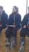 Persons with clipboard sit on hay bale