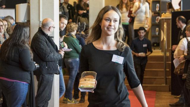 Vrouw loopt langs publiek met Meetgreen burger