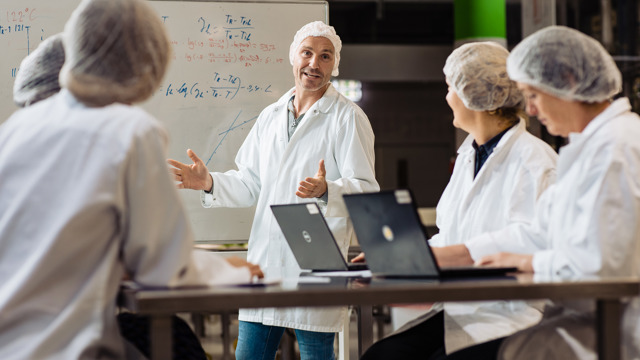 Begeleider en cursisten les in het lab - Leergang Quality and Business Improvement in Food