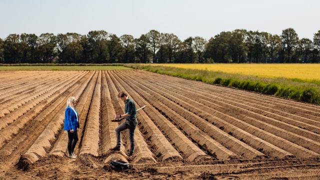 man en vrouw op akker met schop