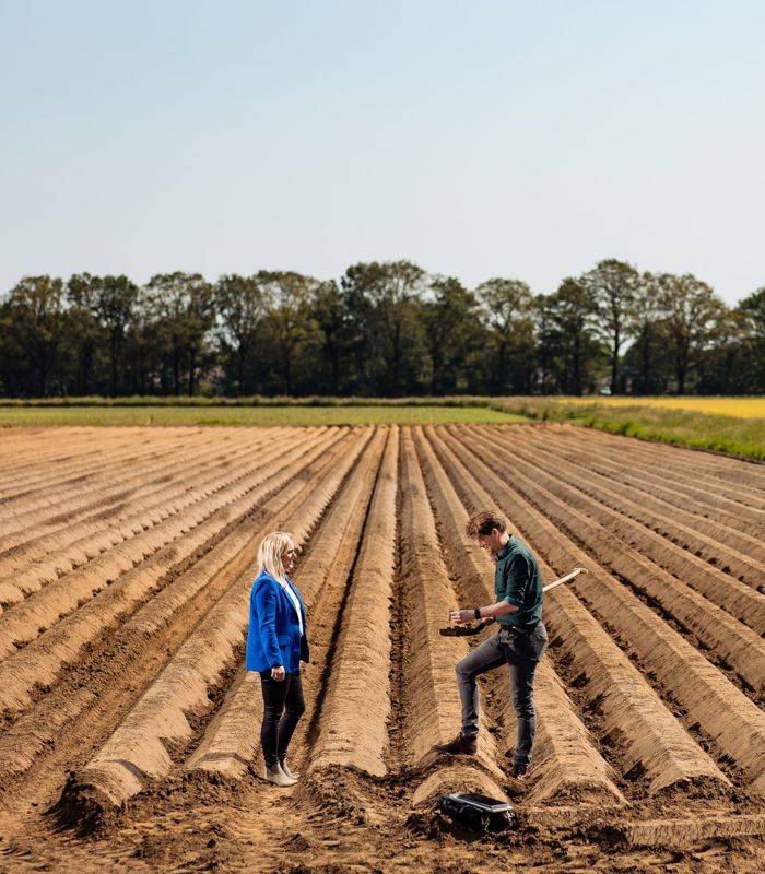 man en vrouw op akker met schop